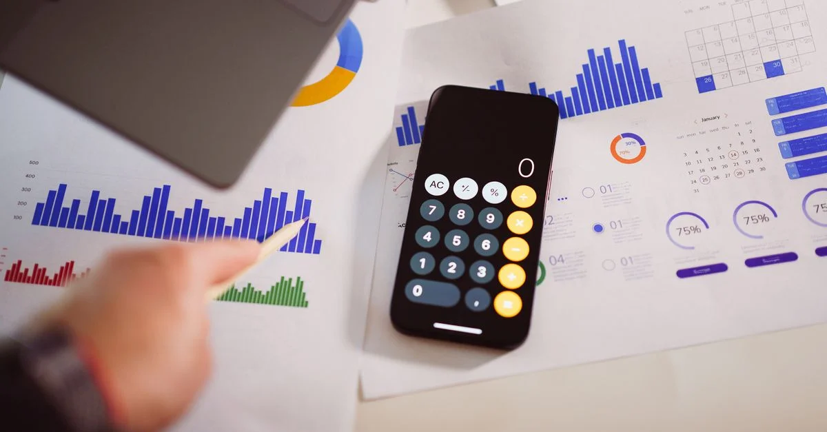 Configuration d'analytique d'affaires avec calculatrice, graphiques et ordinateur portable, montrant des insights financiers.