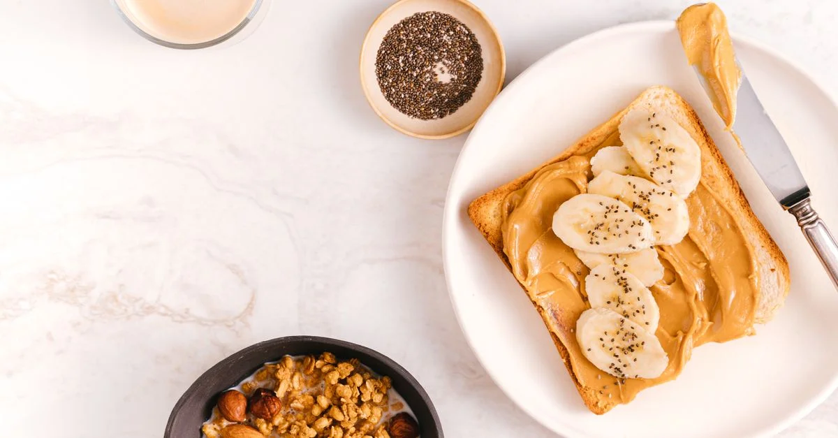 Plan rapproché d'un petit-déjeuner nutritif avec du pain à la banane, des graines de chia et des noix sur une surface en marbre.